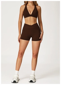 Detail of dark brown yoga set featuring high-waist criss-cross shorts with side pockets