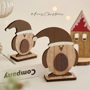 Handcrafted wooden penguin Christmas ornament on desktop with warm lighting decor