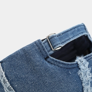 Detail of silver metal buckle and frayed edges on blue denim vintage baseball cap