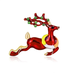 Detail of a jumping reindeer brooch featuring red enamel, gold accents and green rhinestones