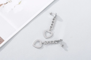 Detail view of silver hollow heart drop earrings with delicate metal chains