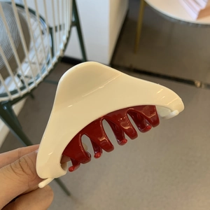 Minimalist triangle claw clip in red and white dual-tone design for thick hair styling