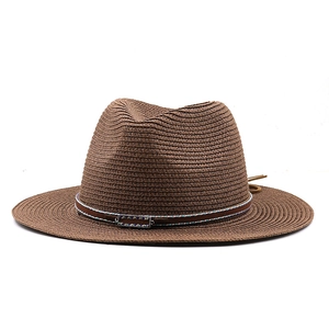 Detailed texture of a dark brown straw fedora hat featuring a vintage metal buckle accent