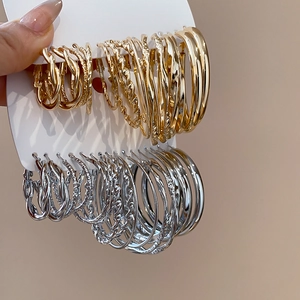 Makroansicht geometrischer Creolen-Set in Gold und Silber mit verschiedenen Texturen