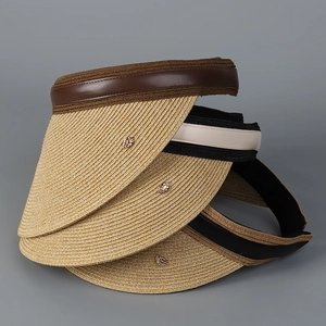 Detailed texture of straw sun visors with leather trim and metal accents in three colors