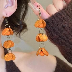 Détails des boucles d'oreilles vintage en perles de bois et formes géométriques oranges