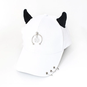 Close-up of white baseball cap featuring black devil horns and metal rings on brim