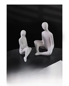 Detail of white matte ceramic abstract human sculptures on marble surface with soft lighting