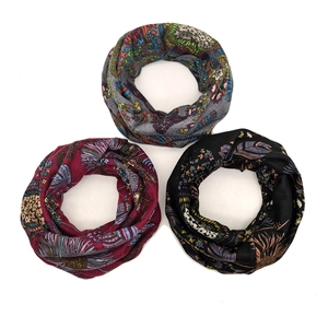 Flat lay of three bohemian floral patterned neck gaiters in grey, burgundy and black