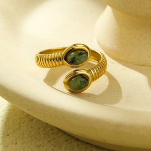 Detailed close-up of a gold stainless steel open ring with two green oval stones