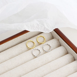Detail of gold and silver hammered hoop earrings presented in a luxury jewelry box