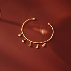 Detailed macro view of 18k gold-plated open bangle with five teardrop zircon tassels