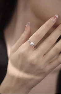 Close-up of sparkling square diamond chain ring on finger showing fine jewelry details