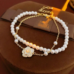 Elegant double-layered pearl bracelet with gold chain and camellia flower pendant