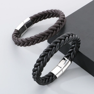 Detail of black and brown braided leather bracelets with polished silver magnetic clasps