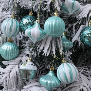 12pcs teal and white Christmas ball ornaments in various shapes on snowy tree branches