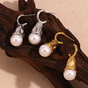 Water drop pearl earrings with hammered 18K gold and silver textures on wood