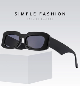 Detailed view of black thick-frame square sunglasses on white geometric stone props