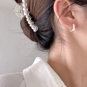 Minimalist square silver geometric hoop earrings and pearl hair clip on female model