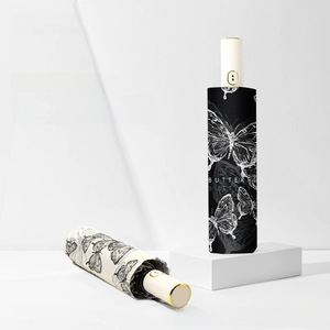 Detailed view of automatic folding umbrellas with butterfly prints and auto-open buttons