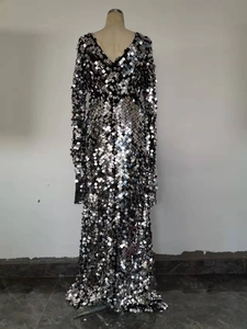 Détail de la robe à paillettes argentées montrant les miroirs métalliques et le col en V