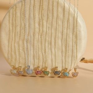 Detailed close-up of zircon bear pendants in eight colors hanging on gold and silver chains
