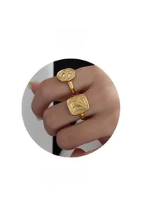 Detail of two gold-plated rings with unique fluid 3D texture on the finger