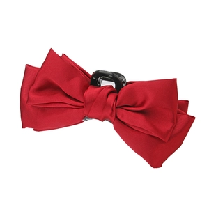 Detailed view of large red satin bow hair claw clip with silk texture and secure grip