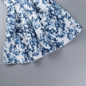 Vue détaillée de l'imprimé floral bleu sur robe en satin blanc avec plis élégants