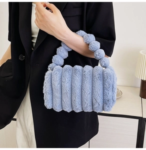 Blue fuzzy plush handbag featuring unique spherical handles and a soft quilted texture