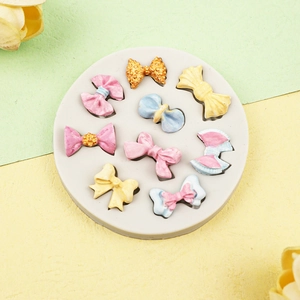 Round silicone fondant mold with various colorful 3D bow shapes for cake decorating