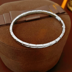 Detailed view of silver geometric link bracelet on premium brown velvet jewelry display