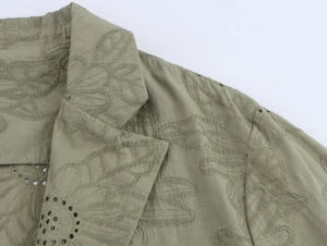 Detailed view of hollow embroidery and stitching on an olive green cotton linen blazer