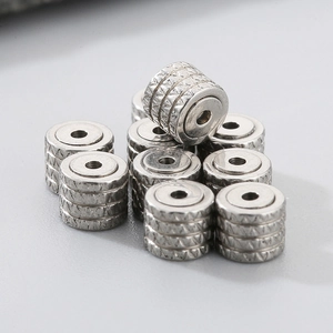 Macro shot of silver stainless steel gear earrings with intricate engraved patterns