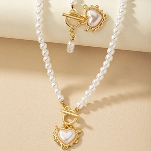 Detail of baroque pearl necklace with golden heart pendant and toggle clasp