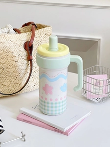 Detail of insulated stainless steel cup with floral patterns and dust-proof straw cap