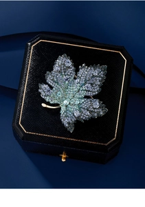 Exquisite maple leaf brooch featuring blue-green gradient crystals and golden metal finish