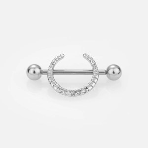 Gros plan de piercings de téton en acier inoxydable avec motif lune, étoile et zircons