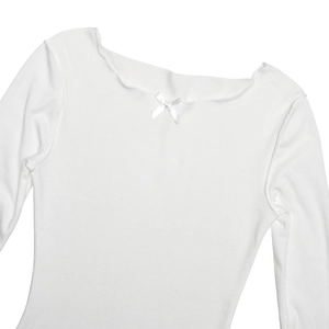 Close-up of white ribbed knit fabric featuring a small decorative bow on the neckline