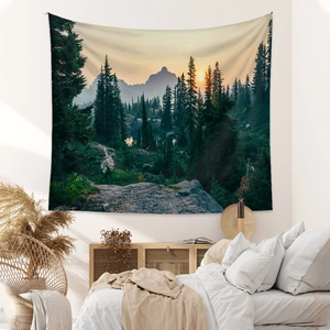 Forest mountain landscape tapestry hanging in a minimalist bedroom with sunset glow