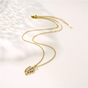 Golden leaf pendant necklace with shimmering zircon stones on a clean white backdrop