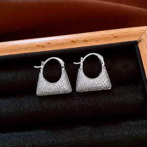 Macro shot of silver zircon earrings in a premium black velvet jewelry box