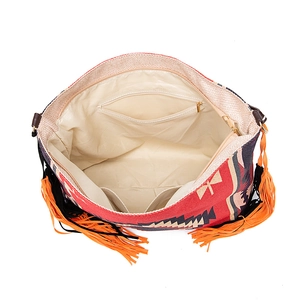 Detail view of the interior lining, zipper pocket, and fringe on this bohemian shoulder bag