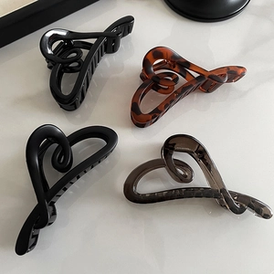 Détail de quatre pinces à cheveux en forme de cœur, coloris écaille et tons unis