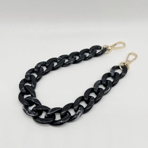 Close-up of acrylic fishbone chain with marble pattern and gold metal lobster clasps