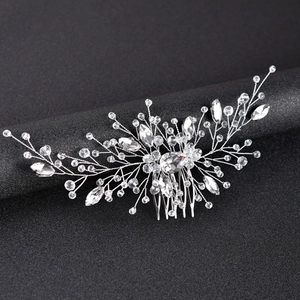 Detail of silver bridal hair comb with emerald crystals and beads in floral design