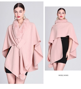 Pink knit cape with faux rabbit fur collar and playful pom-pom tassel details