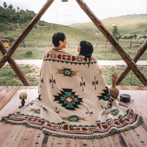 Detailed close-up of tribal geometric jacquard pattern and fringe edge on a camping blanket