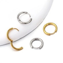 Macro detail of minimalist gold and silver stainless steel hinged hoop earrings