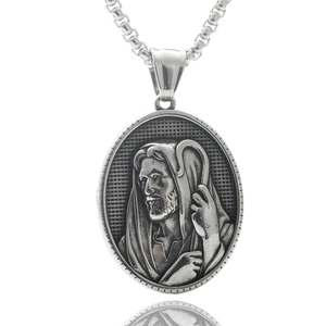 Macro shot of a punk vintage silver stainless steel portrait pendant on white background